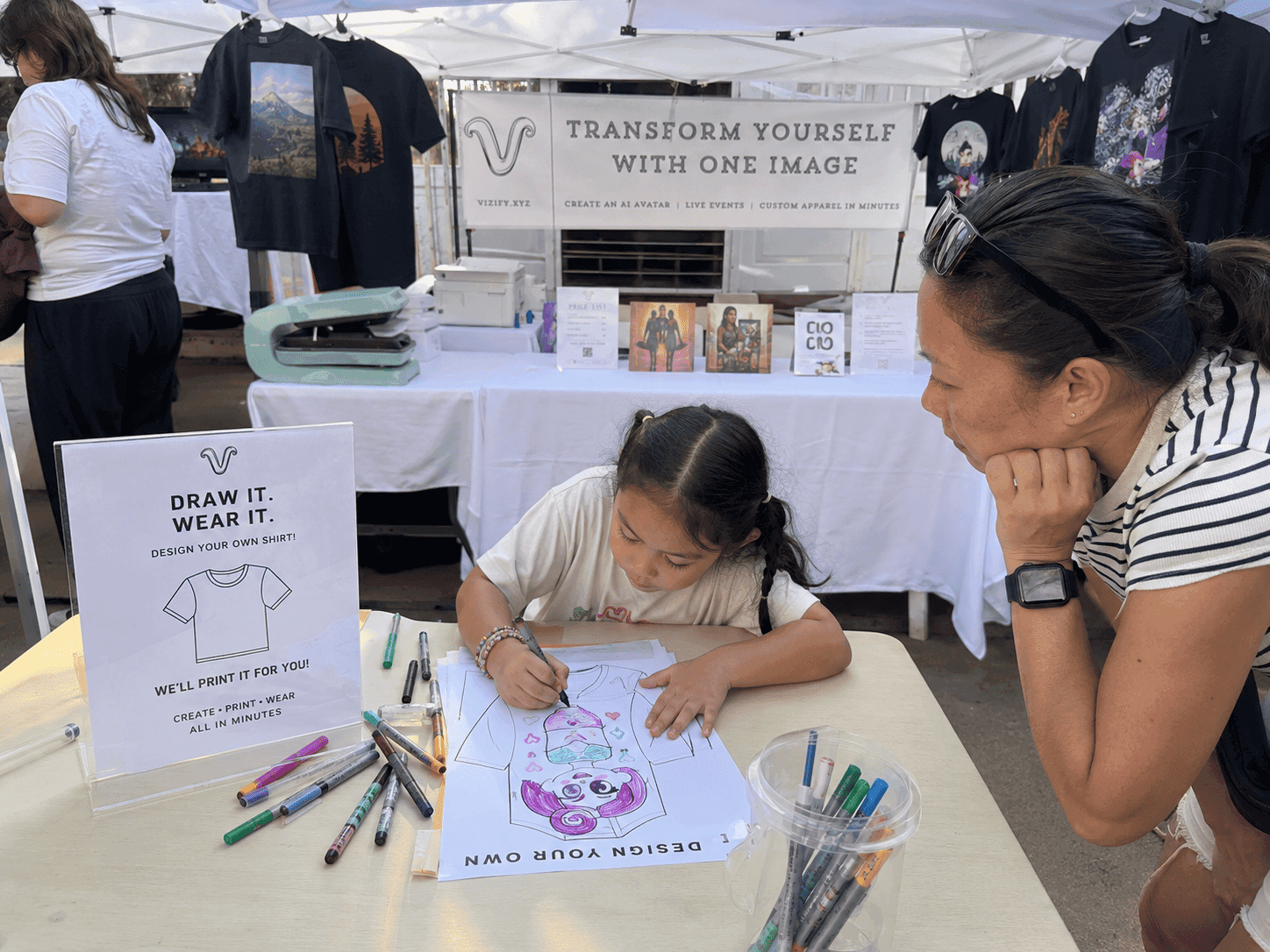 Kid drawing her own shirt design at the table